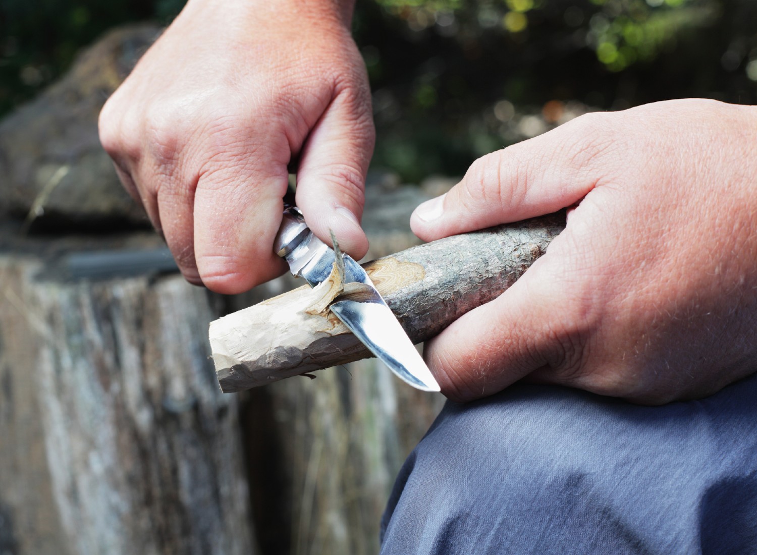 Man carving wood with a knife